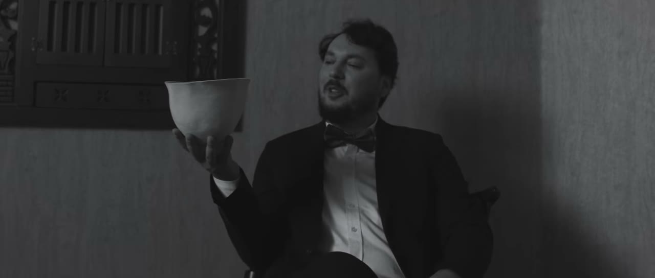 Black-and-white scene from the Nuka brand film — a craftsman with a pillow
