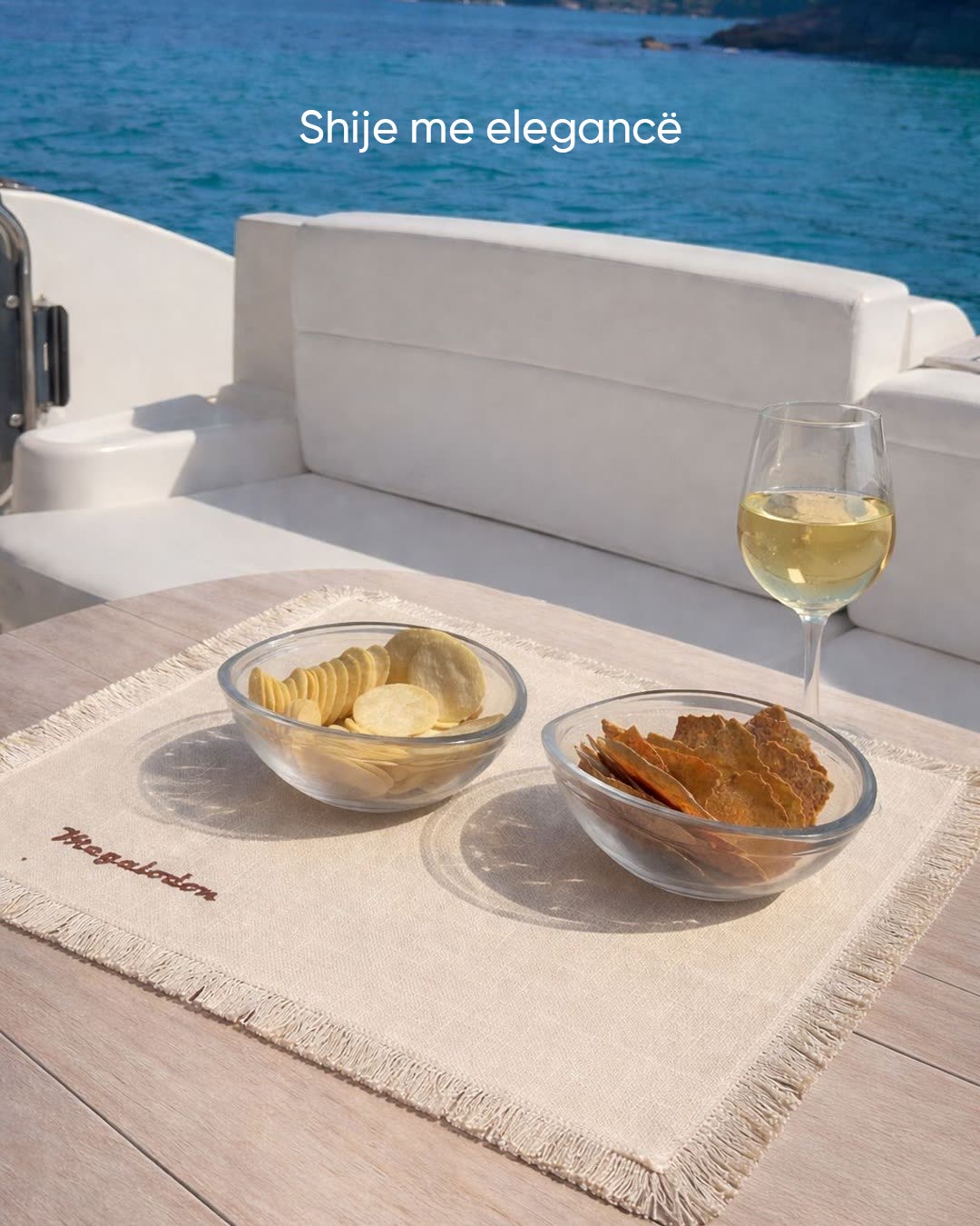 A monogrammed placemat set with wine and appetisers